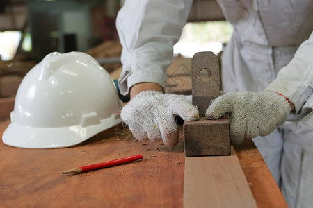 工人在木工车间用手工刨木板的手图片