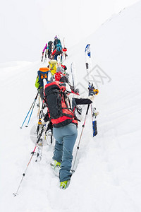 一群跨滑雪者爬上陡峭的斜坡图片