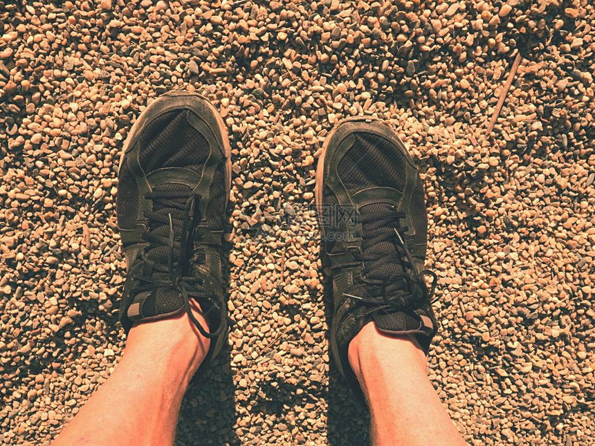 穿着黑色鞋的黑腿在沙地上行走图片