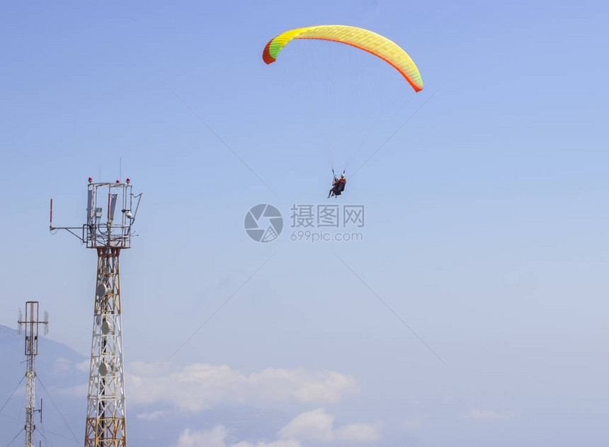 运动滑翔机在天空中飞行滑翔伞对体图片