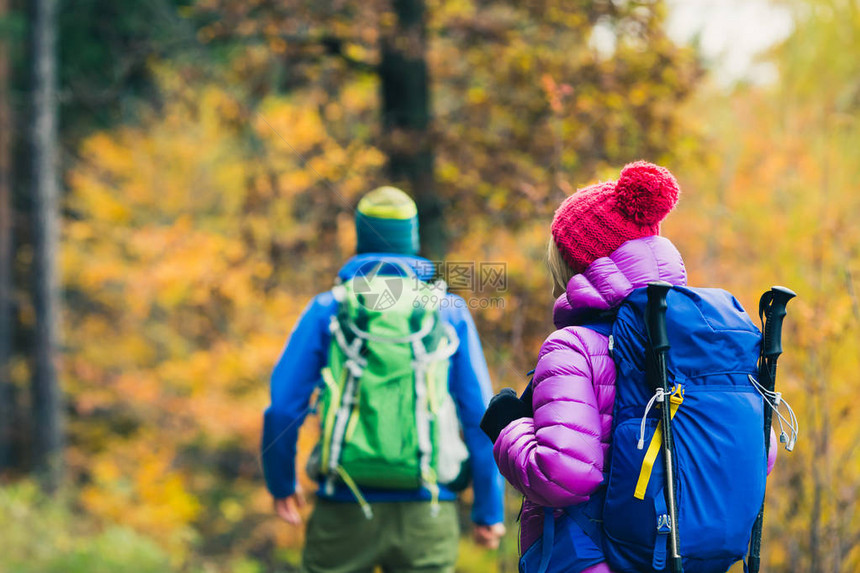 幸福的情侣徒步旅行者在美丽的黄色秋季森林和山脉中徒步旅行图片