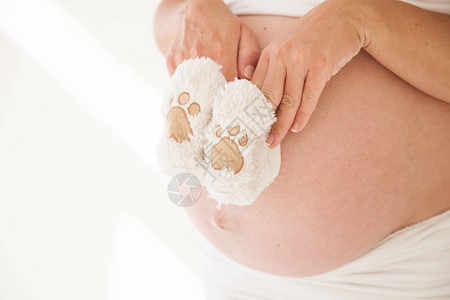 孕妇的肚子和婴儿的袜子图片