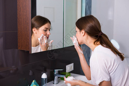 女人早上用泡沫清洁剂洗脸图片