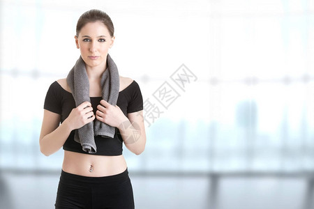 女人用毛巾围着她的脖子休息在健身锻炼后图片