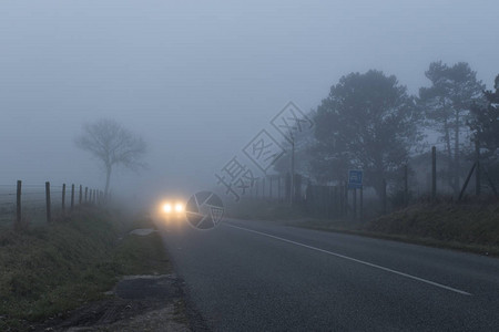 穿过法国诺曼底地区森林和田野的乡村柏油路雾天的乡村景观夜间汽图片