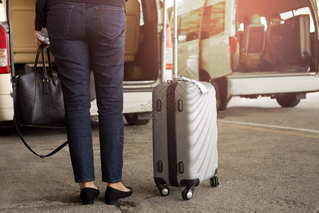 携带行李在机场等待出租车的女游客站图片