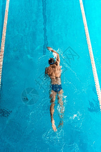 光膀子在游泳池中游泳的人背景