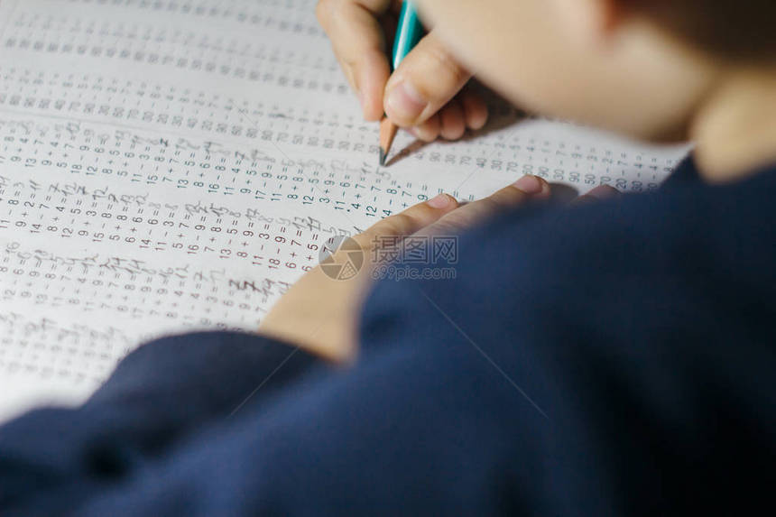 孩子解决数学例子孩子手里拿着铅笔带有乘法表示例的笔记本表学习乘法表的图片