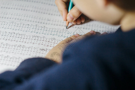 孩子解决数学例子孩子手里拿着铅笔带有乘法表示例的笔记本表学习乘法表的图片