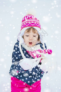 一个孩子在冬天的雪里玩耍图片