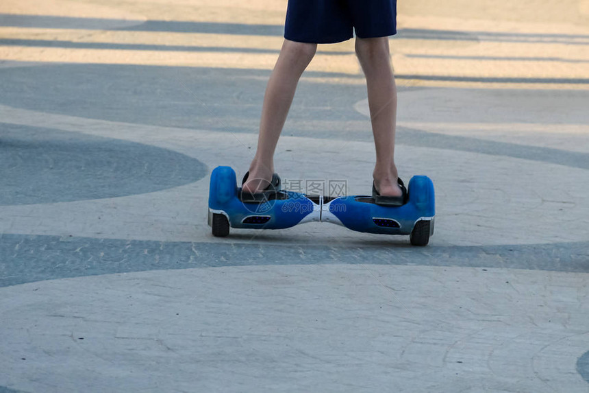 在城市街道上骑着自平衡迷你气垫板的男孩的腿户外电子滑板车个人便携式生态交通工具陀螺滑板车hyroscooter智能平衡轮图片