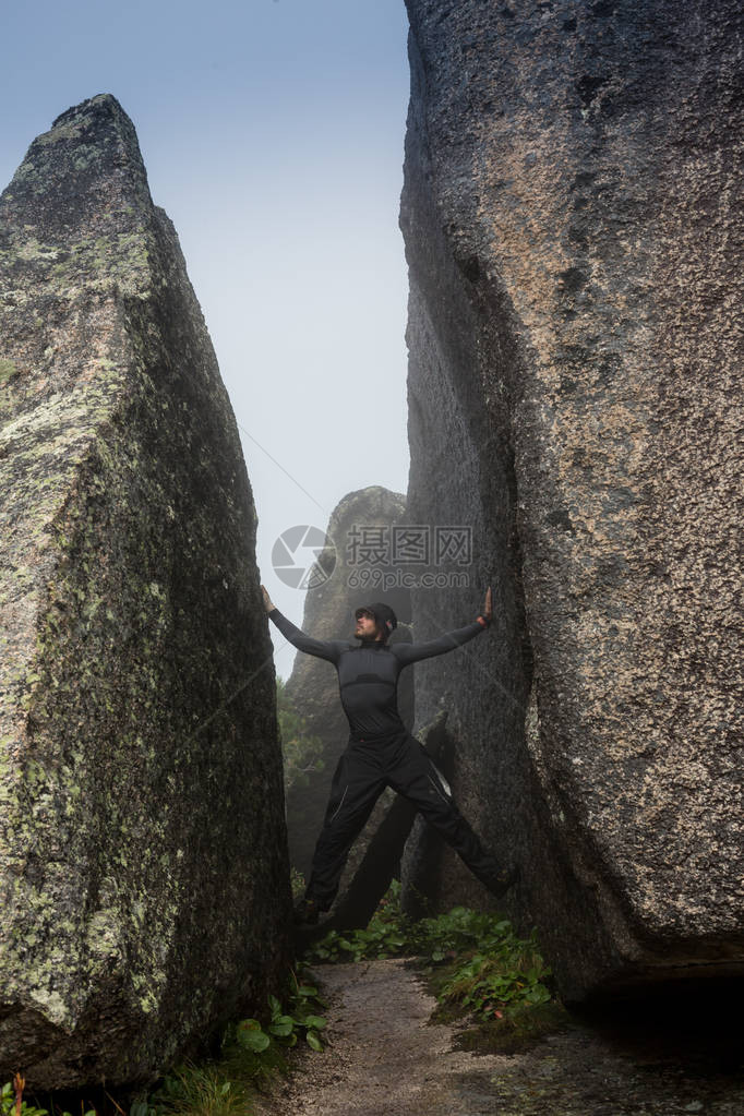 攀岩者爬上冰岛海岸的黑岩石墙上图片