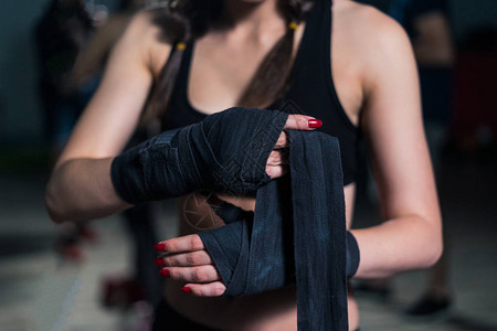年轻拳手击女青年在训练前用重拳袋涂上绷带图片