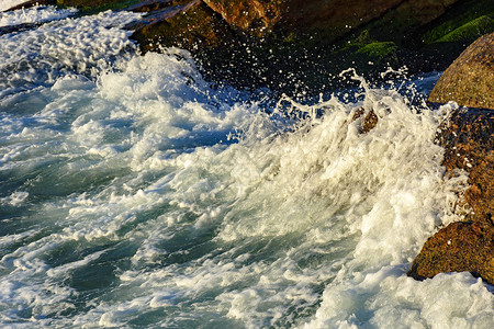 飞溅和水滴与波浪撞击石头图片
