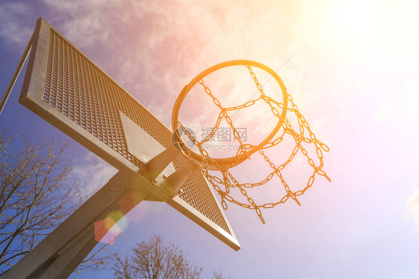 蓝色天空和太阳背景的现代超强金属篮球环图片