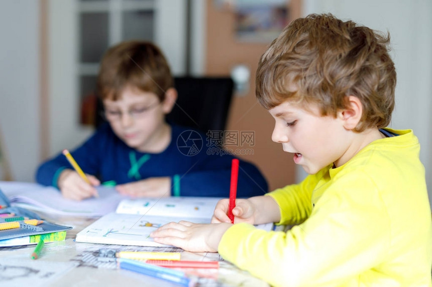 两个小男孩在家做作业集中注意力的孩子们在室内用彩色铅笔写字小学和教育兄弟姐妹和最图片