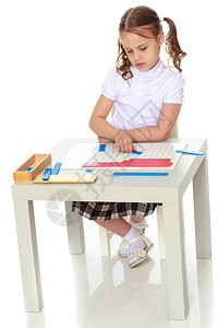 蒙台梭利幼儿园的一个小女孩坐在一张桌子旁学习蒙台梭利的东西图片