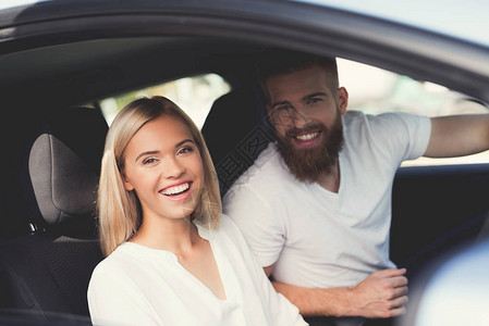一对年轻夫妇正坐在一辆舒适的现代电动汽车的厢里他们心情很好他们图片