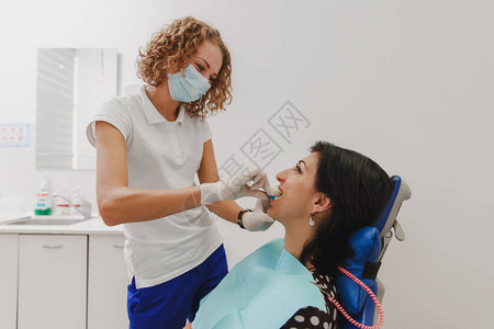 女牙医正在病人的嘴里安装一个装置图片
