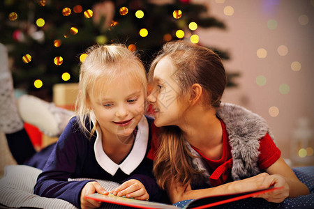 两个可爱的小妹在圣诞树下一起读故图片