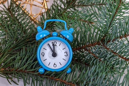 圣诞fir树枝和闹钟在生锈的木制背景上图片