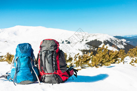 两个背包在雪山和蓝天的背景下雪地上的背包积极的生活方图片