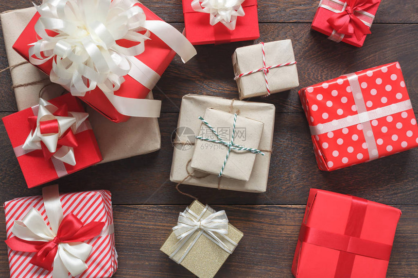 许多彩色礼品盒的顶视图航拍图像现代质朴的棕色木制家庭办公桌上的各种精美物品圣诞快乐和新年或生日快乐背图片