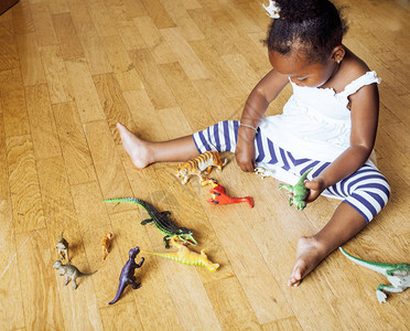 可爱的非洲裔美国小女孩在家玩动物玩具图片