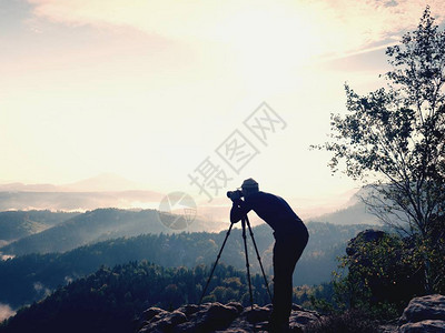 自然摄影师留在顶峰和思维的三脚架上图片