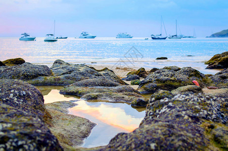 日落时的石滩美丽的日落在岩石海岸图片