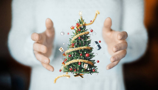 有圣诞树和装饰的手图片