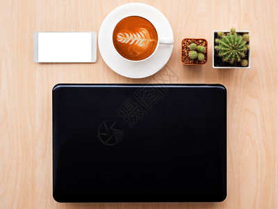 用手提电脑热咖啡仙人掌智能手机在木板上设计工作图片