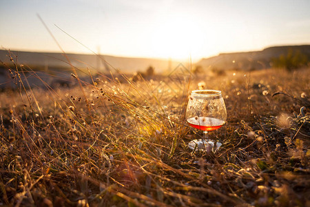 日落时分在干草上喝一杯红酒夕阳下美丽风景的图片