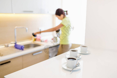 一个在家工作的女人在厨房洗碗和做早餐前图片