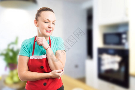 疲倦的妻子管家或女佣在清洁家务后手肘疼痛作为图片