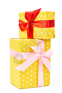 两个黄色点缀礼盒礼物用彩色纸包装圆点图案用美丽的粉红色和红色丝带系图片
