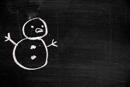 黑板背景上雪人形状的白色粉笔画图片