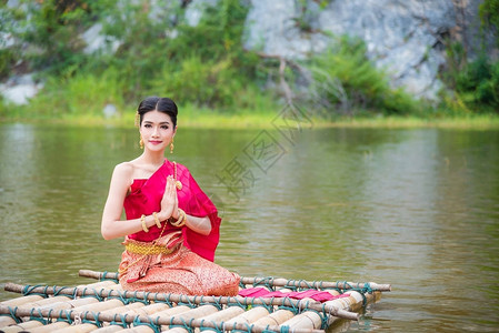 秀水穿着泰国传统服装的美丽的亚洲女人坐在一起背景
