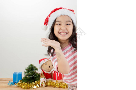 戴圣诞帽子的亚洲快乐儿童拿着白板图片