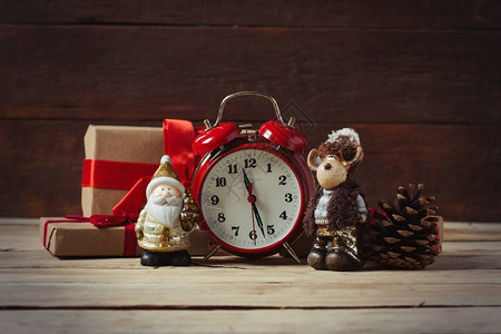 包装礼物圣诞玩具红色时钟和木制背景的圆锥图片