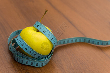 木制桌上的计量磁带和绿苹果饮食和健康生图片