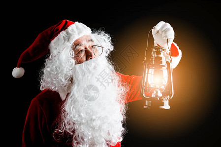 照片是圣诞快乐的圣诞老人与圣诞礼物放在手边图片