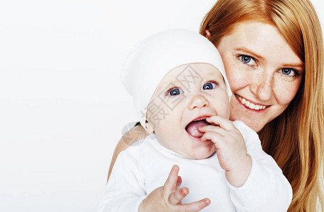 年轻美容母亲怀着婴儿红头的幸福家庭将紧图片