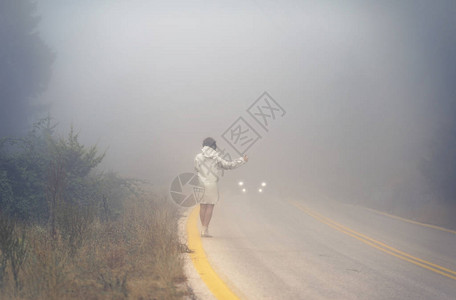 雾中路上穿着雨衣的年轻女穿雨衣的女在雨中图片
