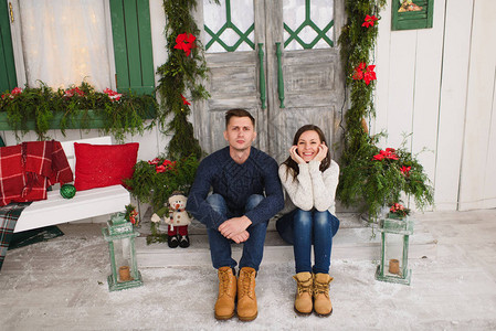 快乐风趣的恋爱中的年轻夫妇穿着毛衣坐在灯塔的门廊台阶上图片