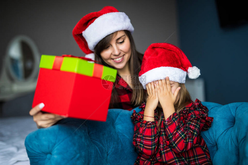 年轻的母亲秀惊讶圣诞老人的礼物白色小女儿在家里闭上眼睛兴奋的小女孩从妈手中得到惊图片
