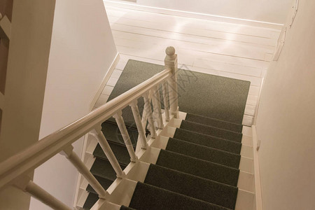 白色木楼梯绿色地毯下楼图片