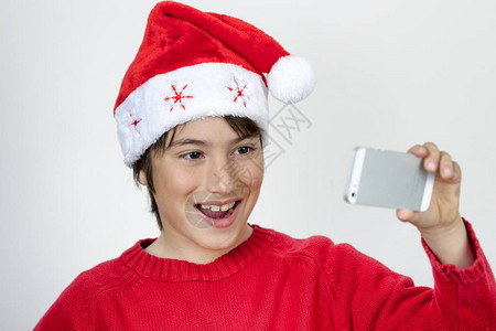 戴着圣诞帽的小男孩开心地自拍背景图片