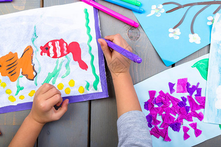 儿童绘画儿童双手的顶端视图和纸上图片