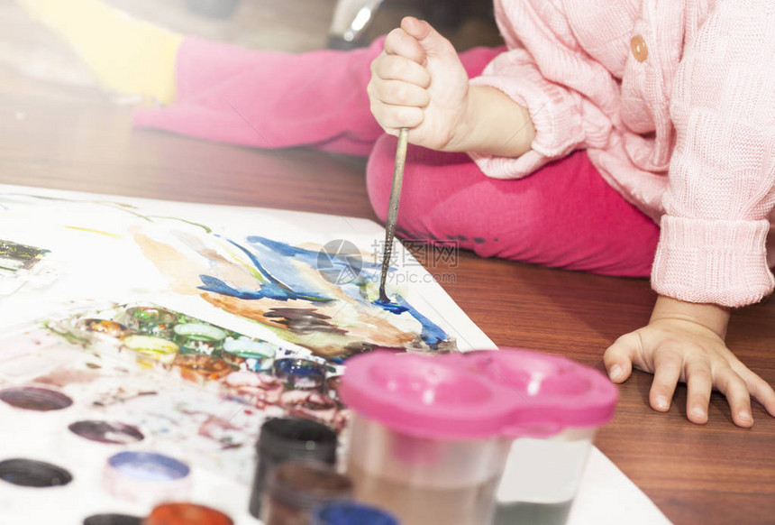 一个孩子用铅笔和刷子画一幅画图片